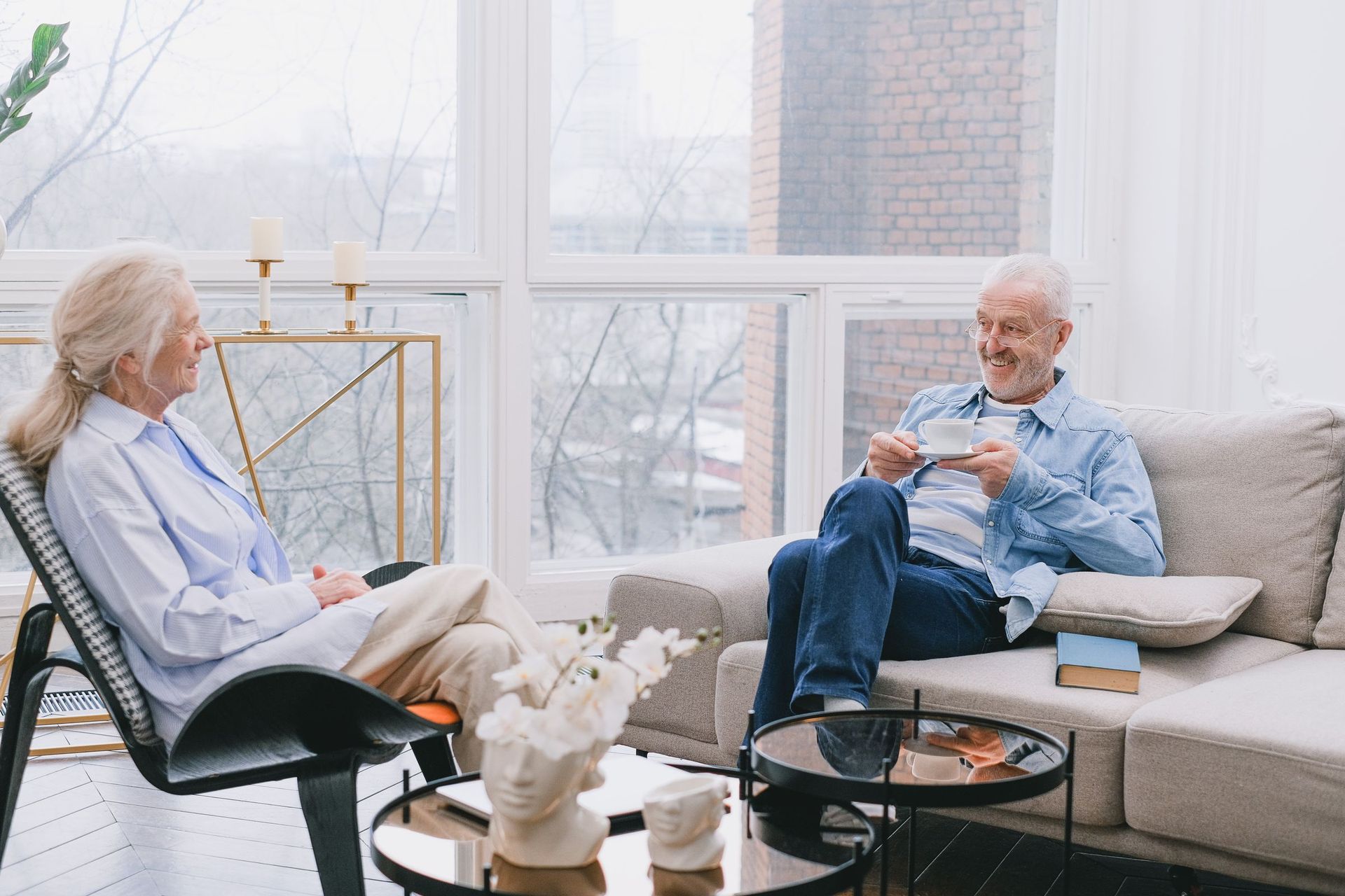 An older couple relaxing with tea in a sunlit living room