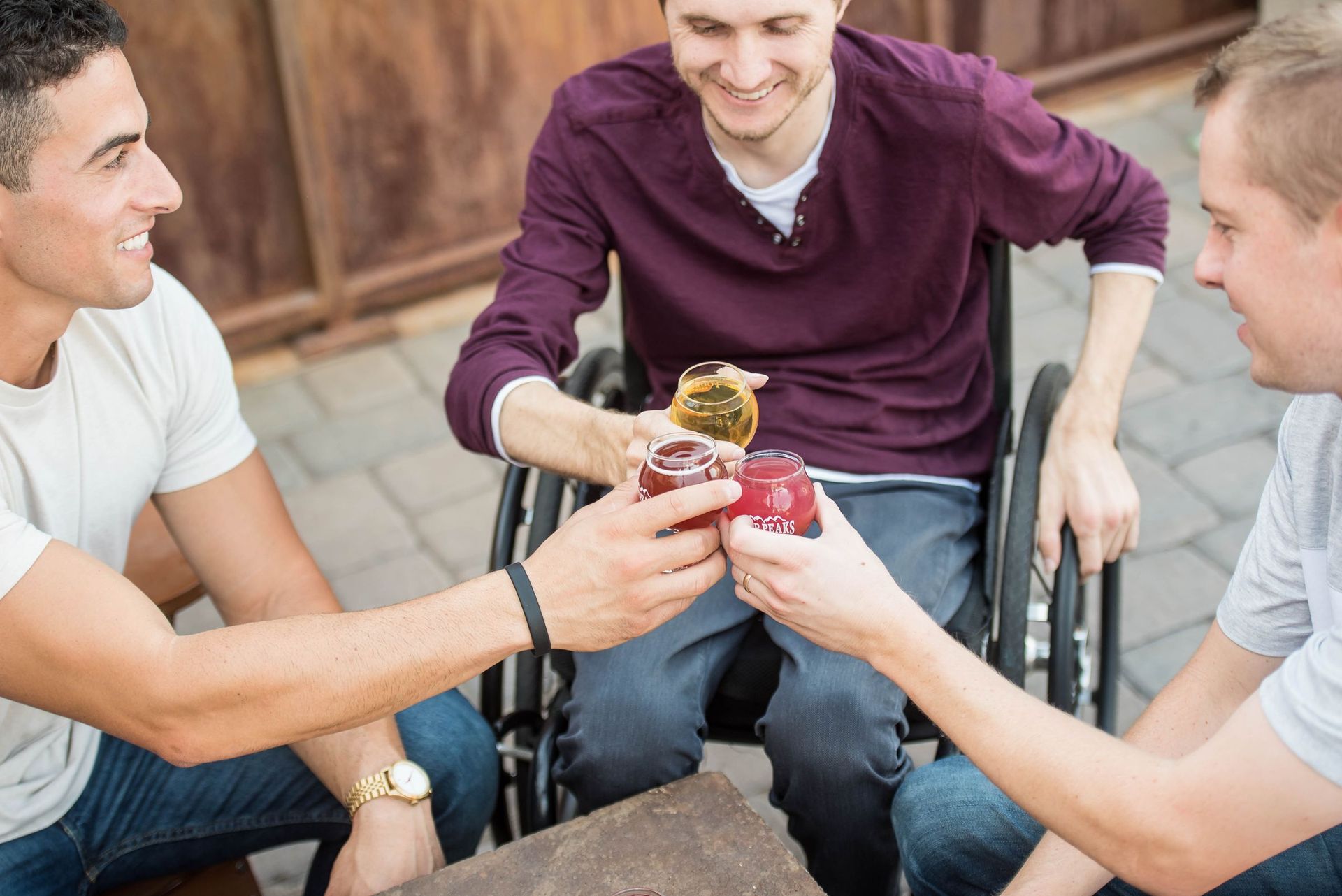 Friends sharing a drink with a man who uses a wheelchair