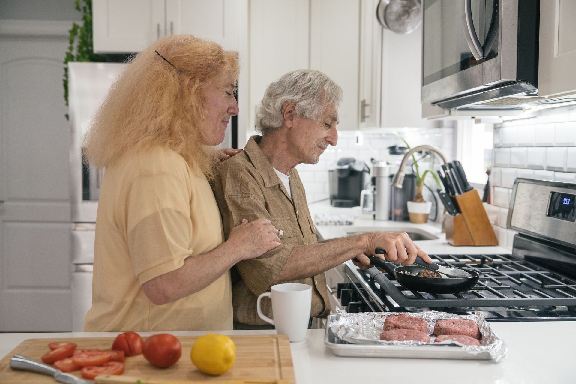 An older couple cooking together at home