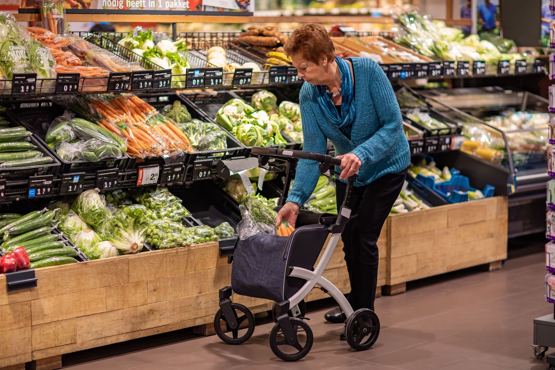 A woman doing her own food shopping with a rollator