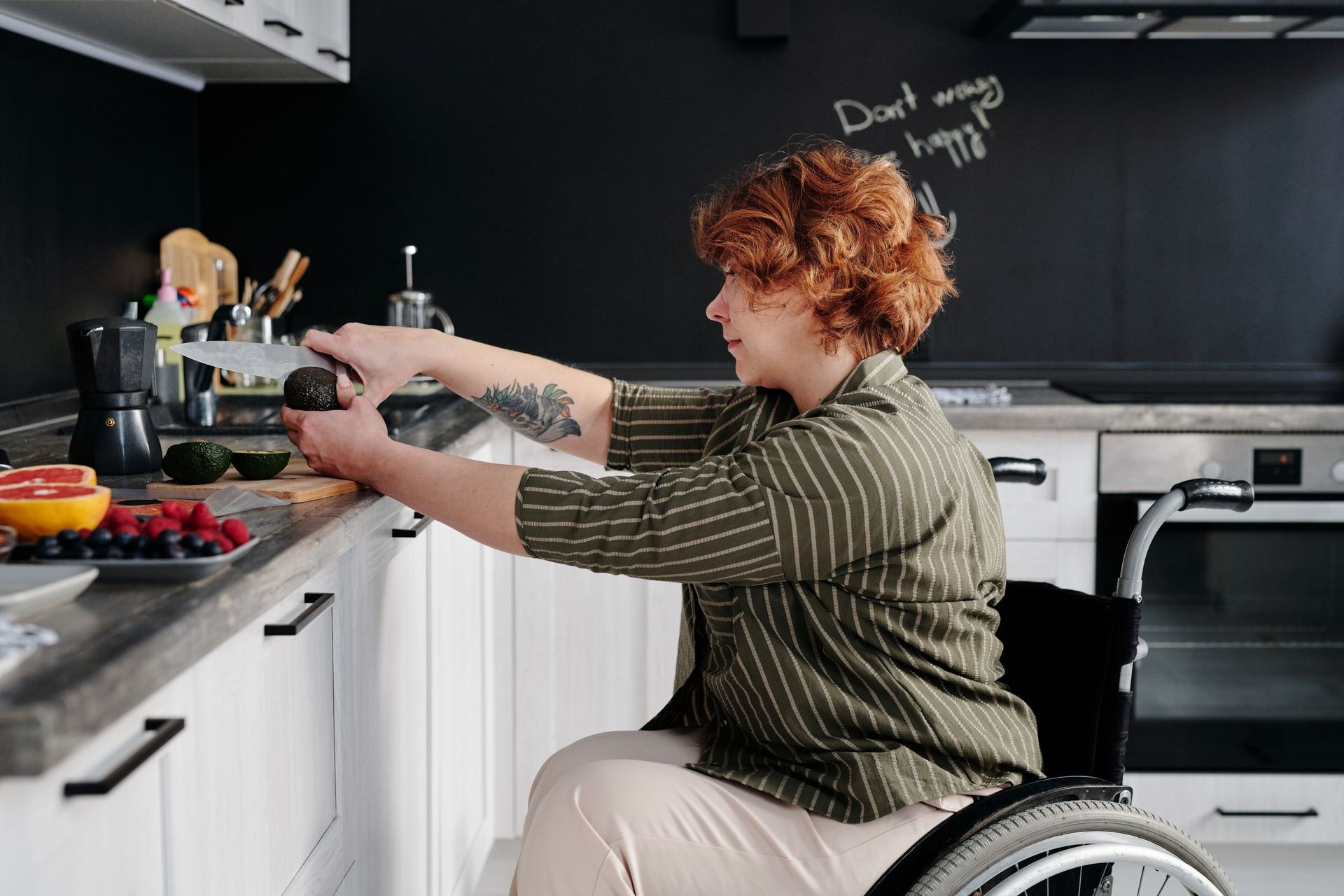 A woman in a wheelchair cooking in an accessible kitchen