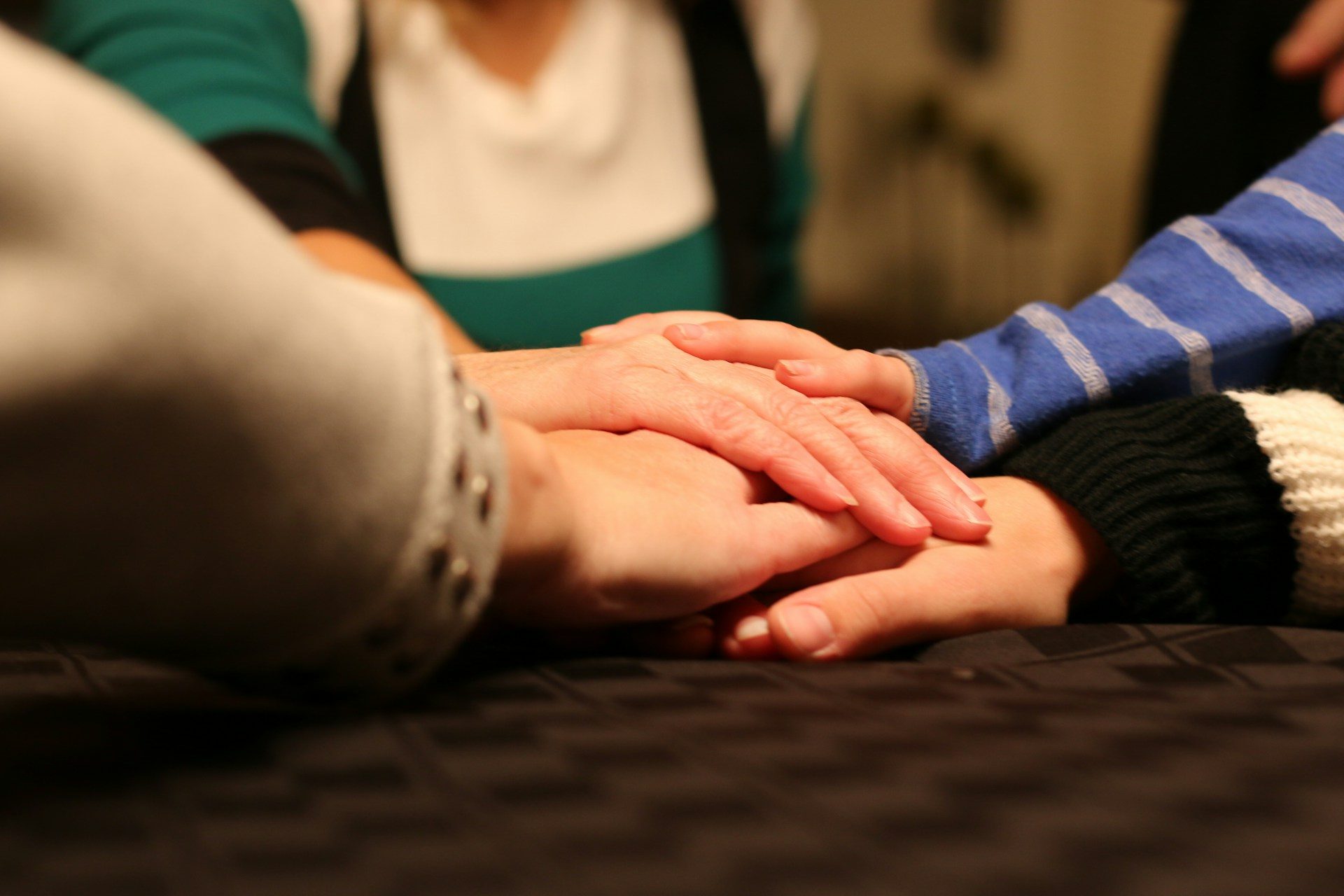 Hands resting together, supporting an older person at home